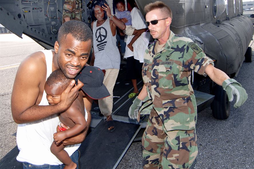 A soldier directs Hurricane Katrina victims as they exit the back of an Army CH-47 Chinook helicopter 