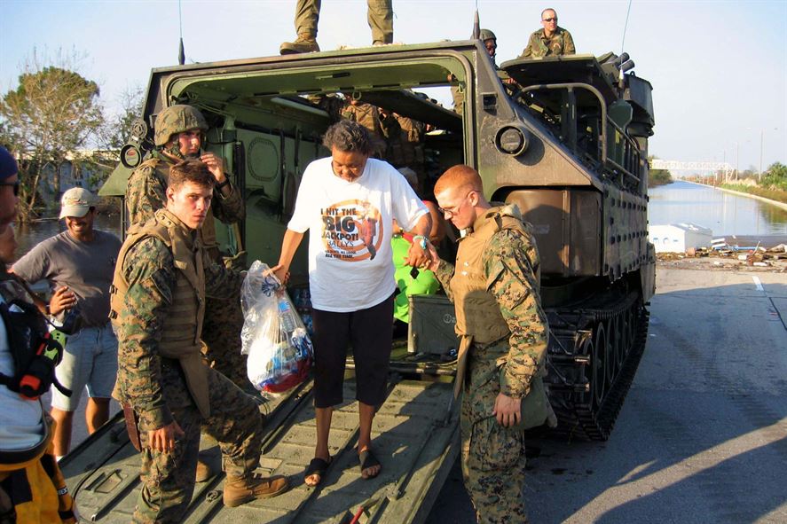 Marines assist Evelin Jenkins out of their assault amphibian vehicle