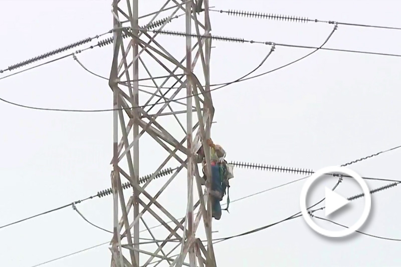Screengrab of a technician working on fixing a powerline.