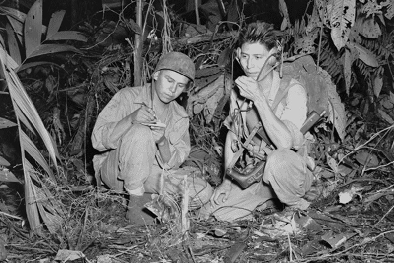 Navajo Code Talkers Marine Corps Cpl. Henry Bake, Jr. and Pfc. George H. Kirk use a portable radio near enemy lines.
