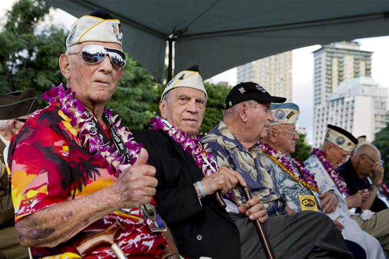 Bob Addott, left, giving a thumbs up as he and Thomas Petso attend the opening ceremony of the Pearl Harbor Memorial Parade on Fort DeRussy Park in Honolulu.