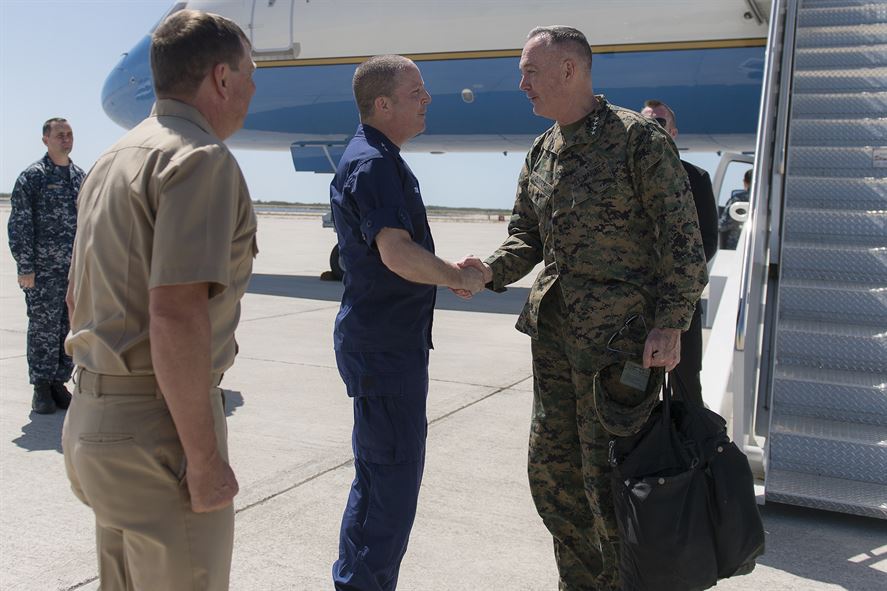 Marine Corps Gen. Joseph F. Dunford Jr., right, chairman of the Joint Chiefs of Staff, exchanges greetings with Coast Guard Rear Adm. Chris Tomney, director of Joint Interagency Task Force South