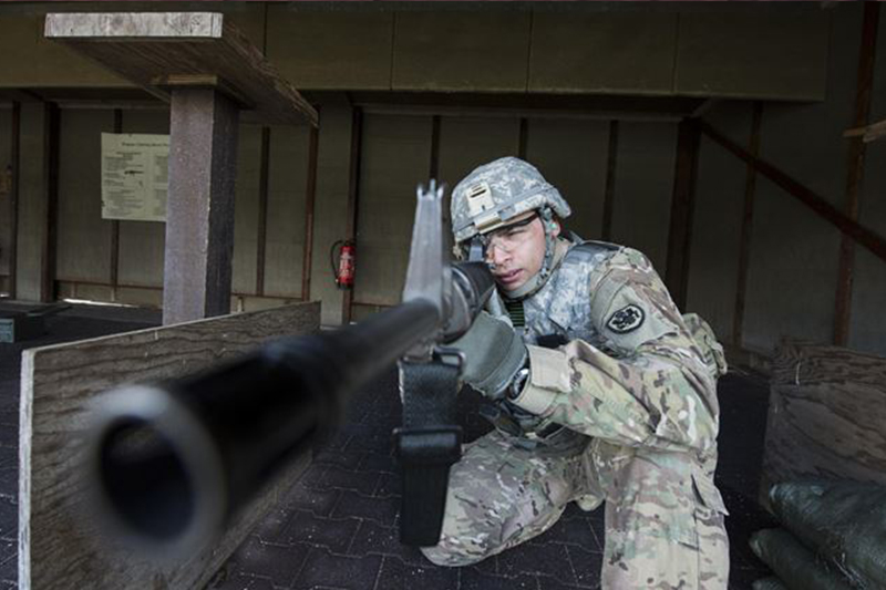 Army Spc. Demel Cooper sights an M16 rifle.