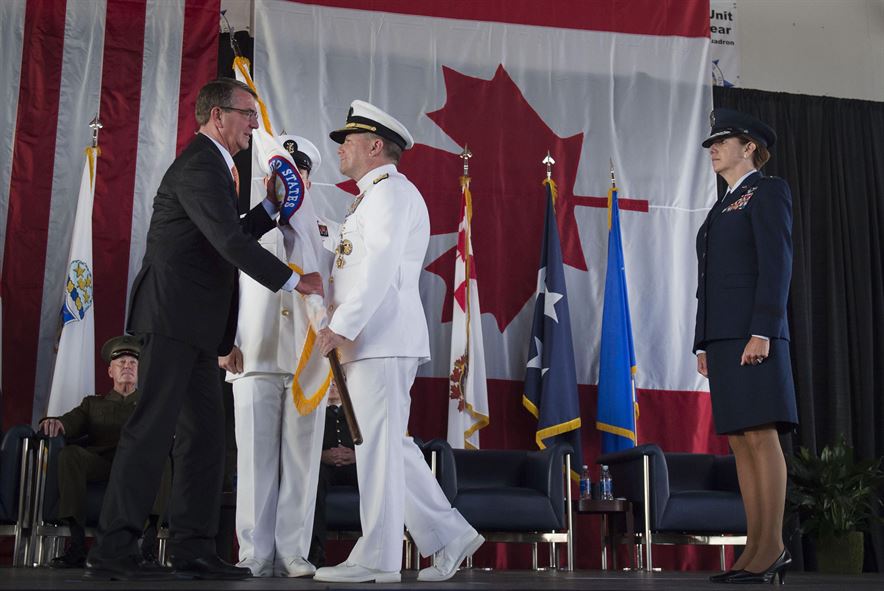 Navy Adm. Bill Gortney hands Defense Secretary Ash Carter a U.S. Northern Command flag 