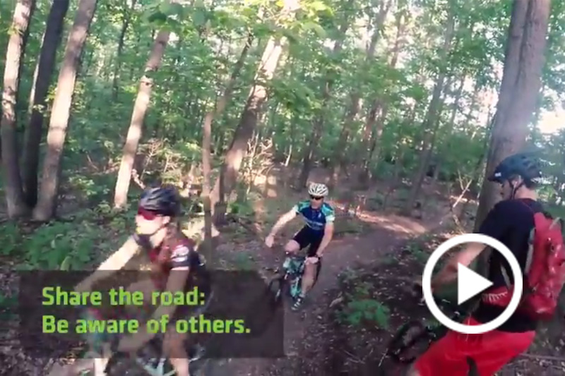 Screen grab of people riding bikes int he woods.