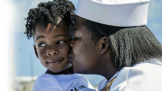 Navy Petty Officer 1st Class Ashley Johnson kisses her daughter