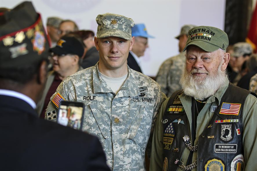 A young Army Maj. Zach Rolf poses for a photo with his elderly bearded father and Vietnam War veteran, Lynn Rolf