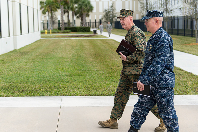 Marine Corps Gen. Joseph F. Dunford Jr., left, chairman of the Joint Chiefs of Staff, walks with Navy Adm. Kurt W. Tidd, commander, U.S. Southern Command, walking into SOCOM headquarters.