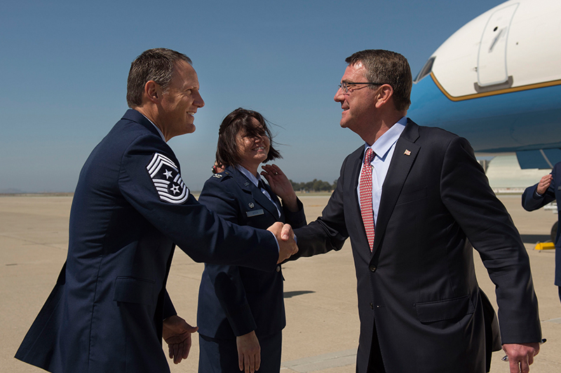 Defense Secretary Ash Carter shaking hands with Air Force Chief Master Sgt. Steven J. Pyszka, command chief of the 129th Maintenance Group.