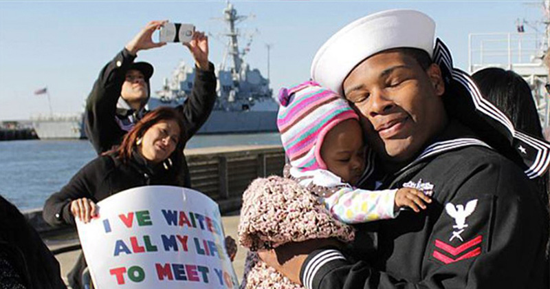 Navy Petty Officer 2nd Class Marcus Harris meets his daughter for the first time during a homecoming celebration for the guided-missile destroyer USS Barry in Norfolk, Va., Nov. 8, 2013.