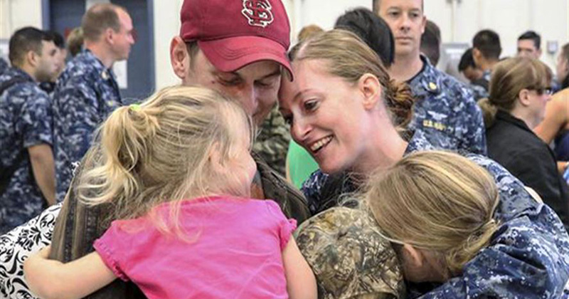 Navy Petty Officer 2nd Class Amelia Powell hugs her family at Naval Air Station Whidbey Island, Wash., July 13, 2016, after returning from deployment.