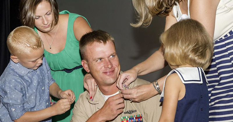 Newly promoted Navy Chief Petty Officer Jamie Steinbrunner is pinned by his family during a ceremony at Joint Base Pearl Harbor-Hickam, Hawaii, Sept. 16, 2016.