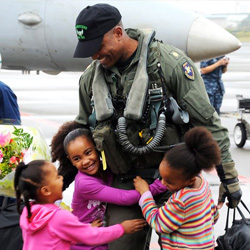 Navy Lt. Cmdr. Victor Glover greets his daughters at the Naval Air Facility Atsugi airfield, Japan, Oct. 26, 2010, during his squadron's homecoming celebration. 