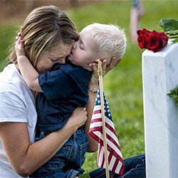 Brittany Jacobs hugs her 17-month old son Christian at her husband, Marine Sgt. Christopher Jacobs’ gravesite at Arlington National Cemetery, Va., May 25, 2013.